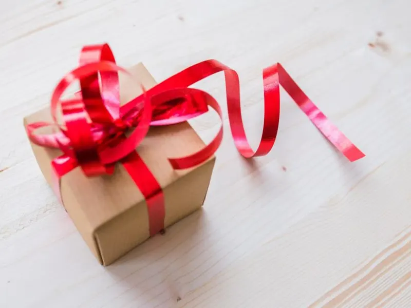 Small gift box wrapped with red ribbon