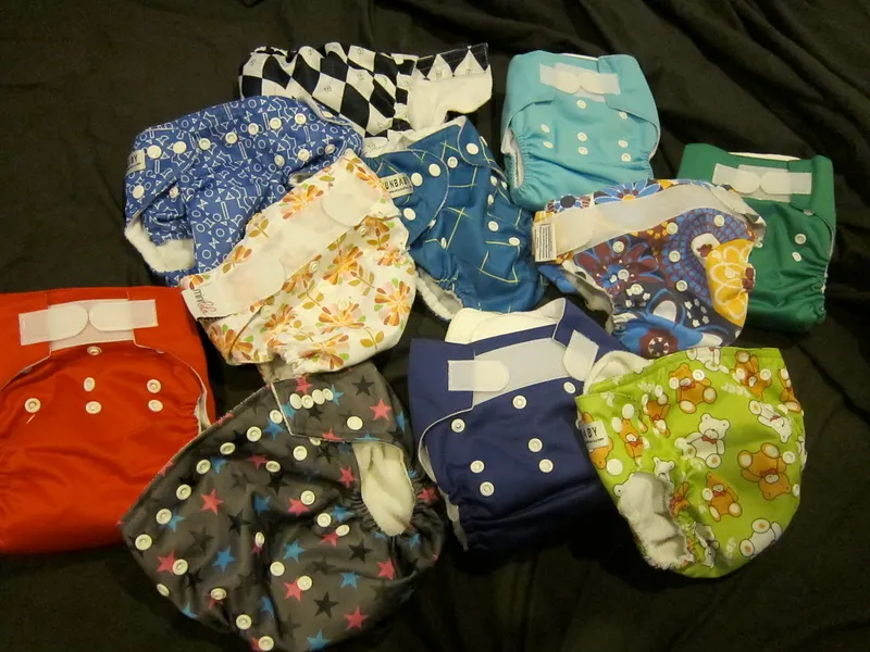 Colourful stash of reusable cloth nappies laid out