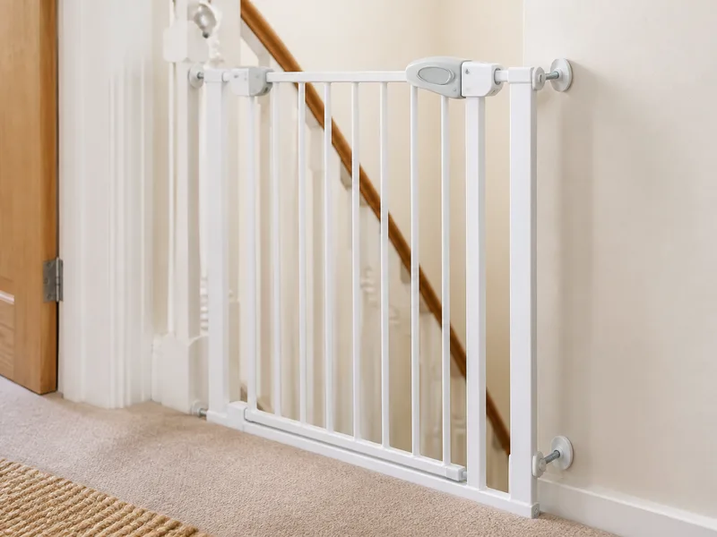 White safety stair gate fitted at the top of stairs