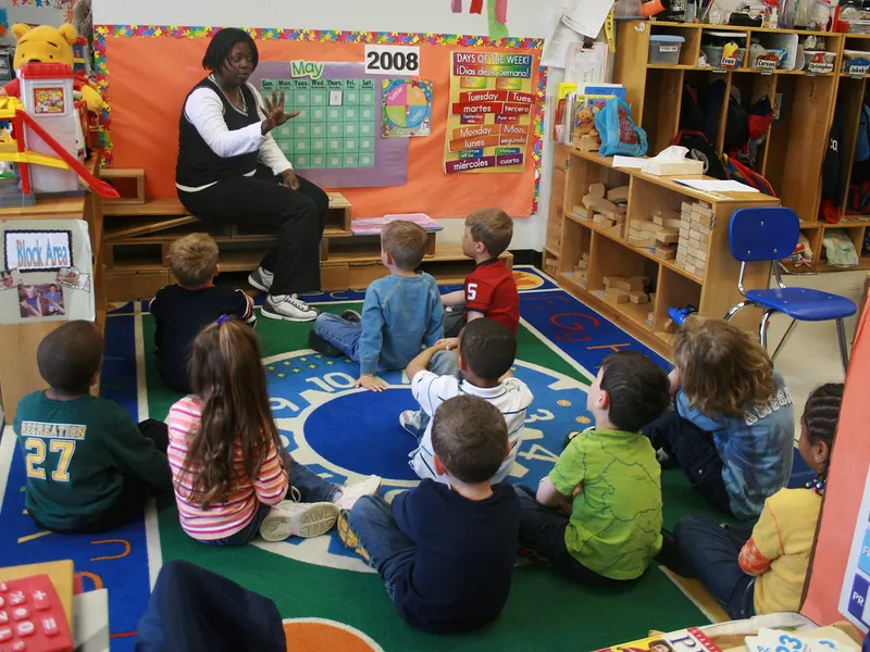 Children sitting on a colourful rug at nursery