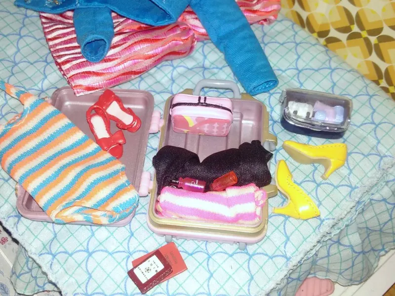 Small suitcase packed with folded clothes on a bed