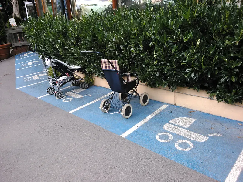 Pushchairs parked in a painted pram-parking bay