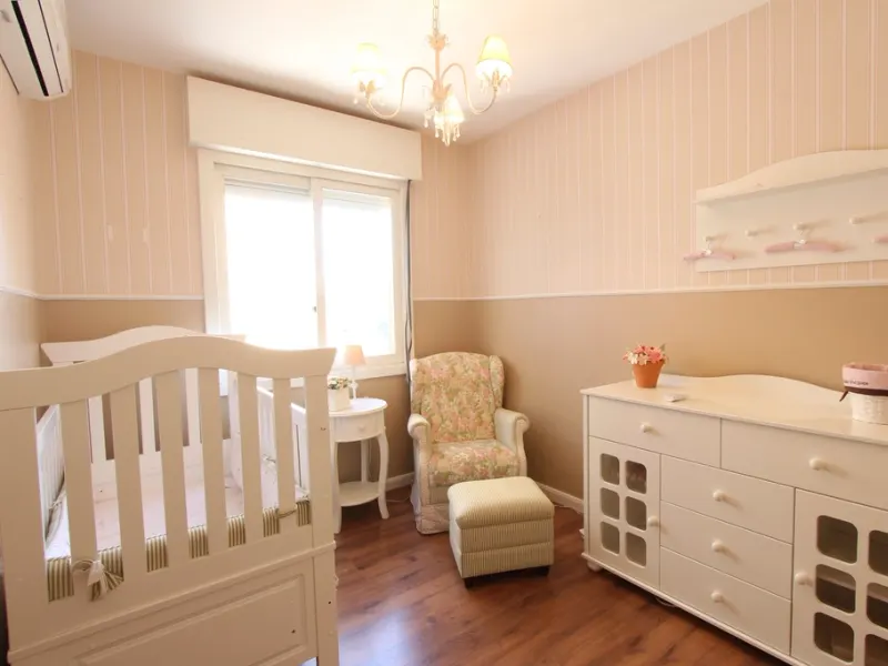 Bright nursery with a white cot and dresser
