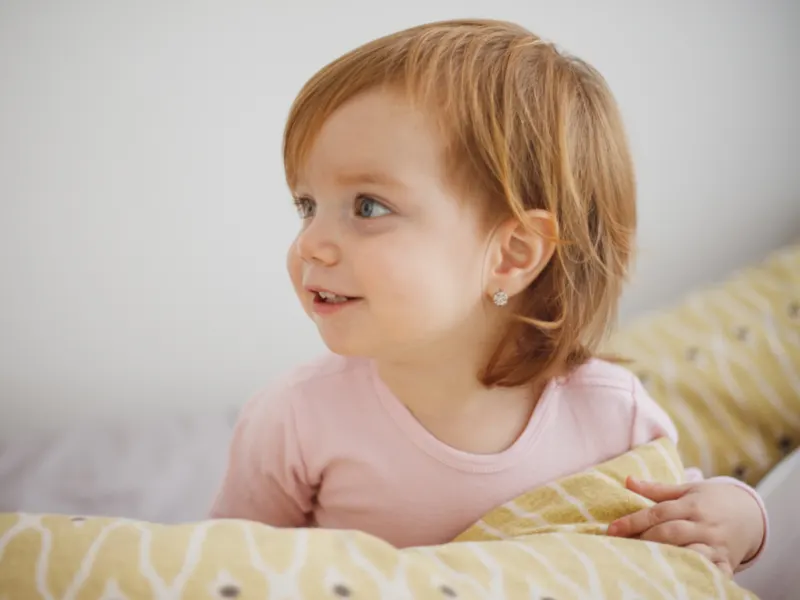 Happy baby girl looking up while playing