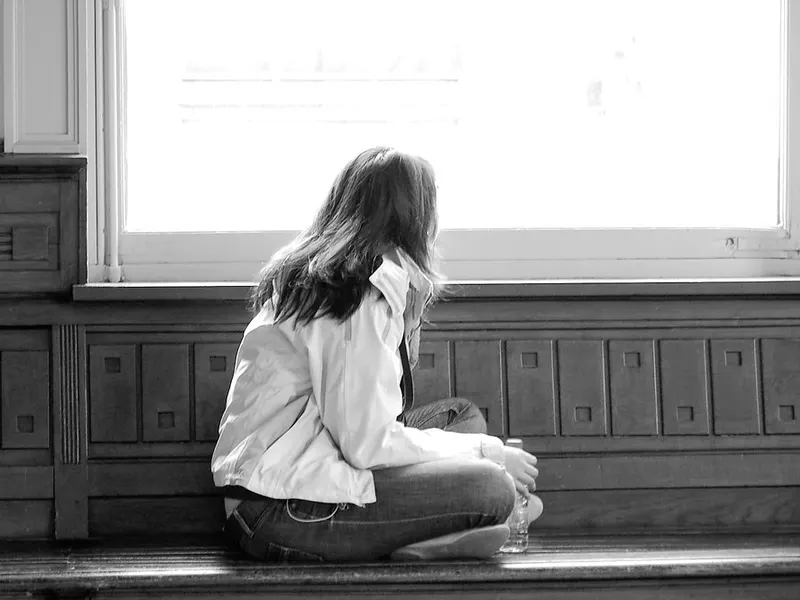 Woman sitting quietly by a bright window
