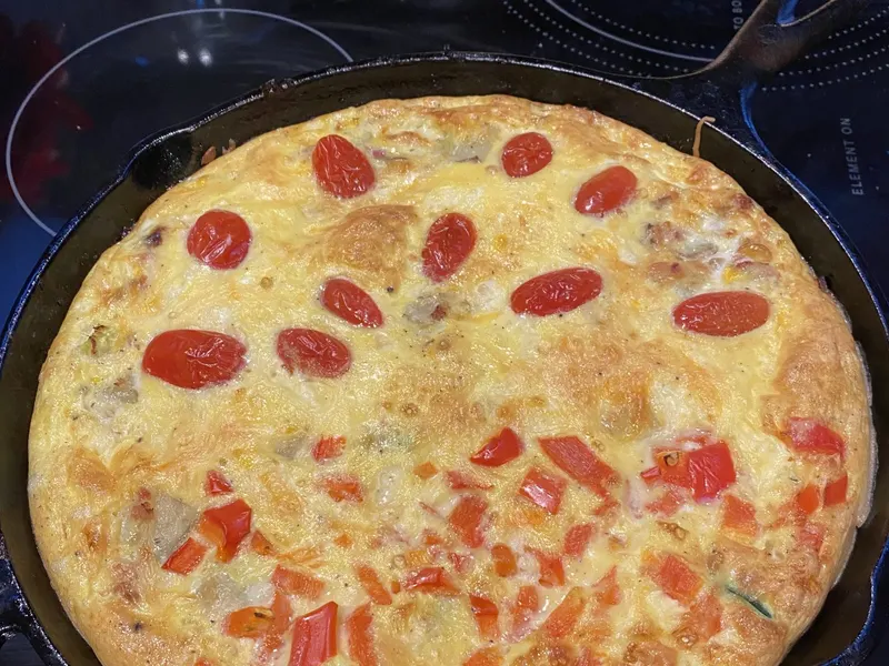 Frittata with cherry tomatoes and cheese in a pan