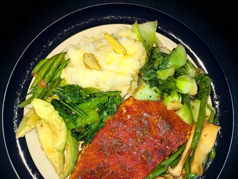 Plate of salmon with mashed potato and green vegetables