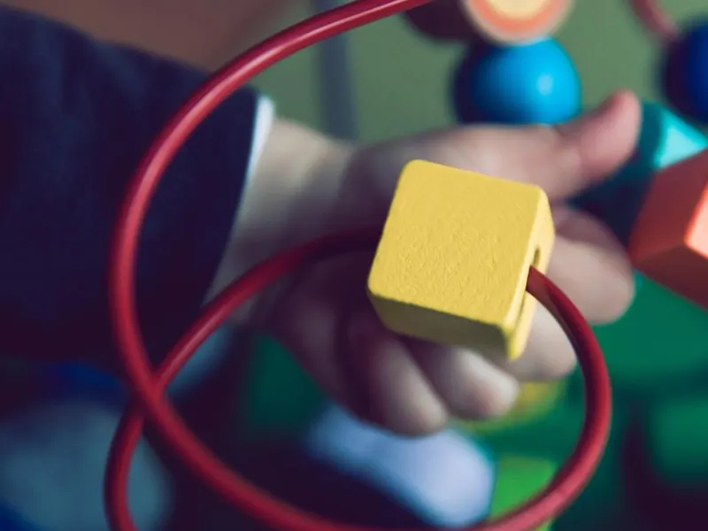 Child’s hands playing with colourful building blocks