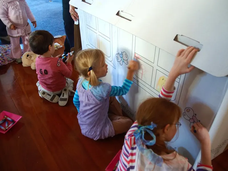 Children playing at a nursery activity wall