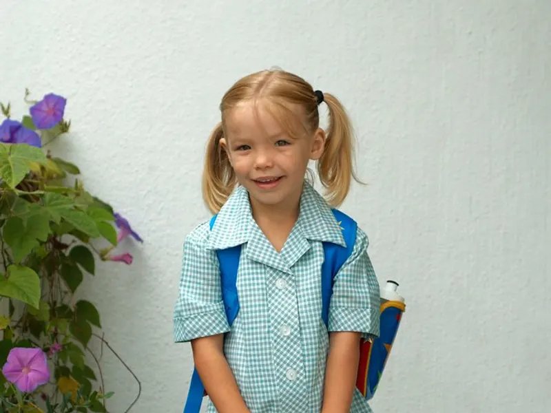 Young girl in school uniform with a backpack