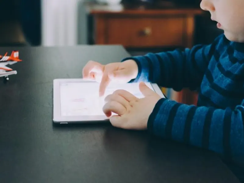 Young child using a tablet at a table