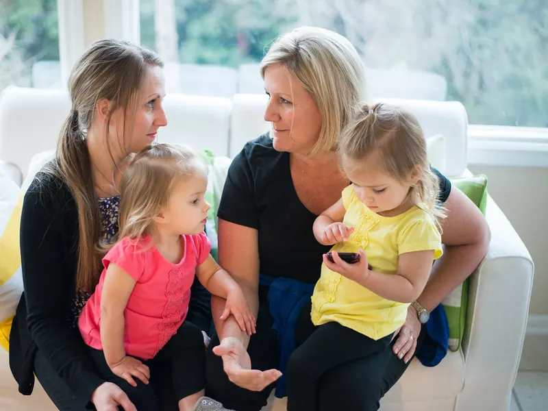 Mothers chatting with their toddlers on a sofa