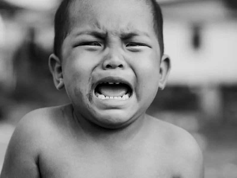Crying toddler mid-tantrum, black and white portrait