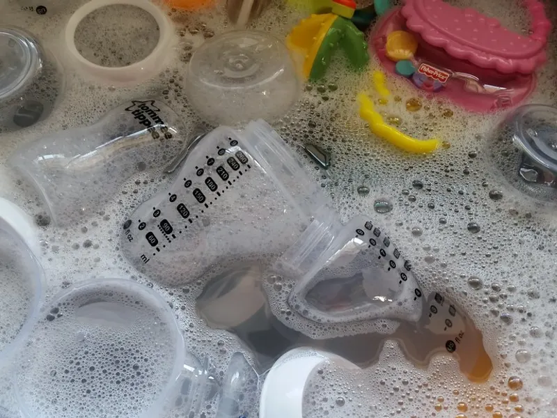 Baby bottles being washed in soapy water